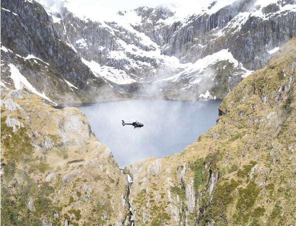 Heli Glenorchy aircraft flying over Fiordland National Park.
