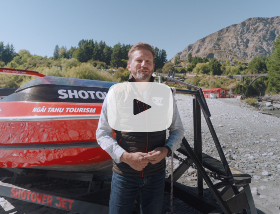 Man standing in front of a Shotover Jet electric boat.