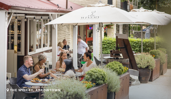 A group of friends enjoying a drink and snacks at The Winery in Arrowtown in spring