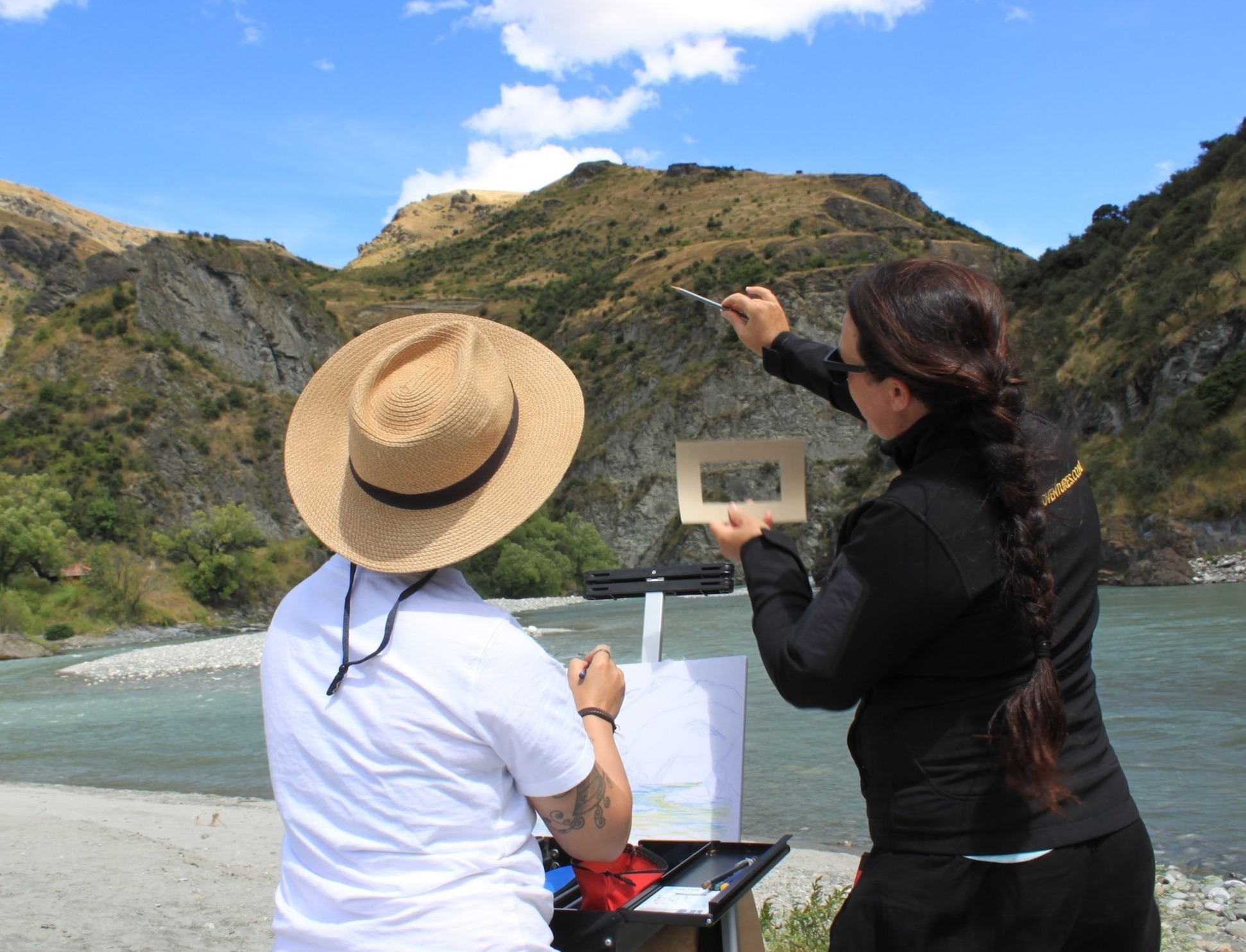 A person on an Art Adventures tour, with guide pointing at a mountain 