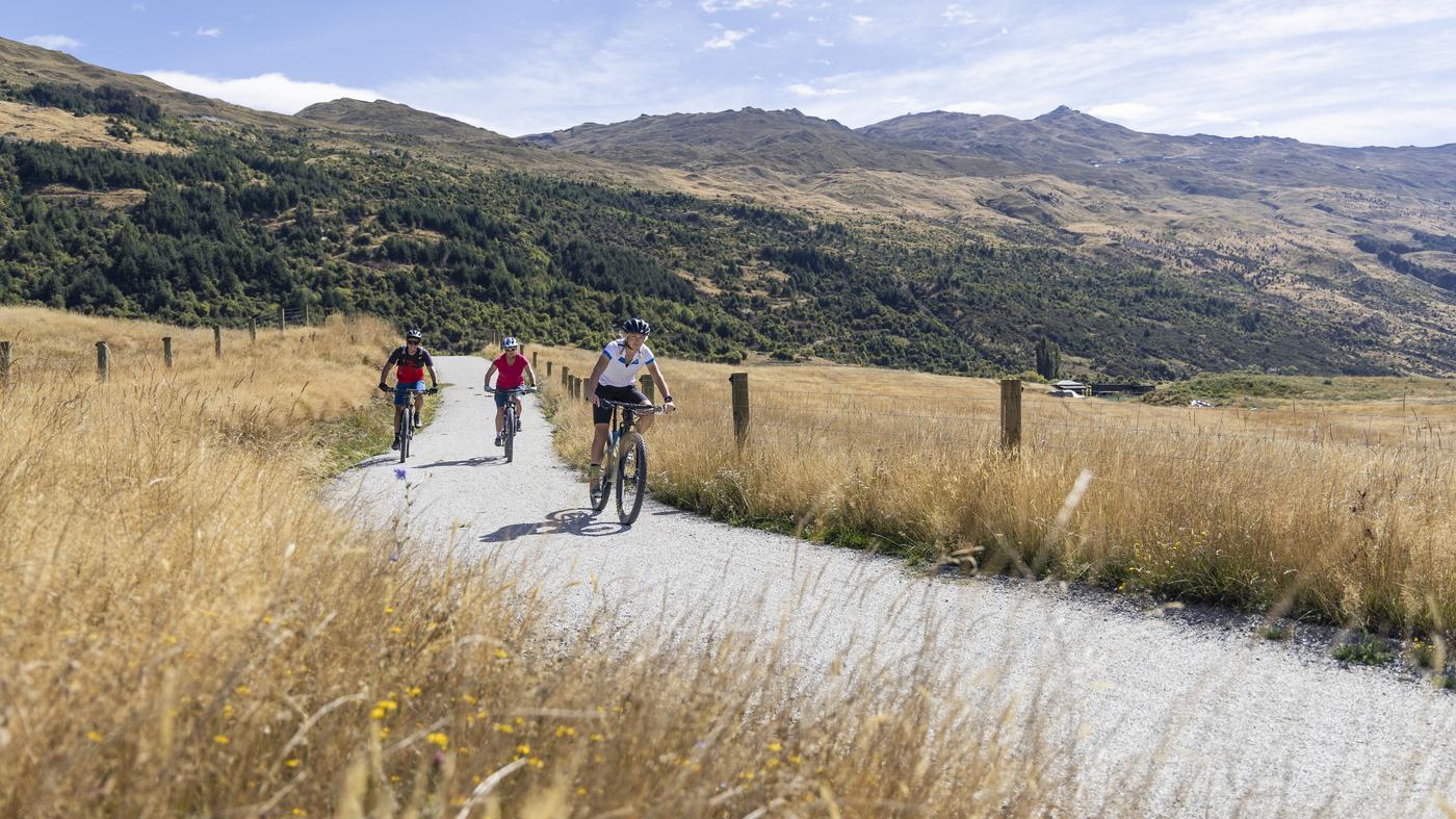 Three people ride the new Wharehuanui Trail a sunny day