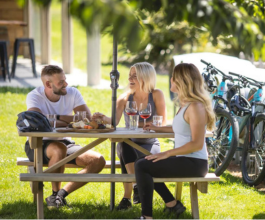 A group of friends enjoy food and wine at Kinross on a sunny day