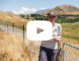 Still from Slope Hill Planting Project - Whakatipu Reforestation Trust & Love Queenstown Impact Story video. With YouTube play button symbol in the centre.