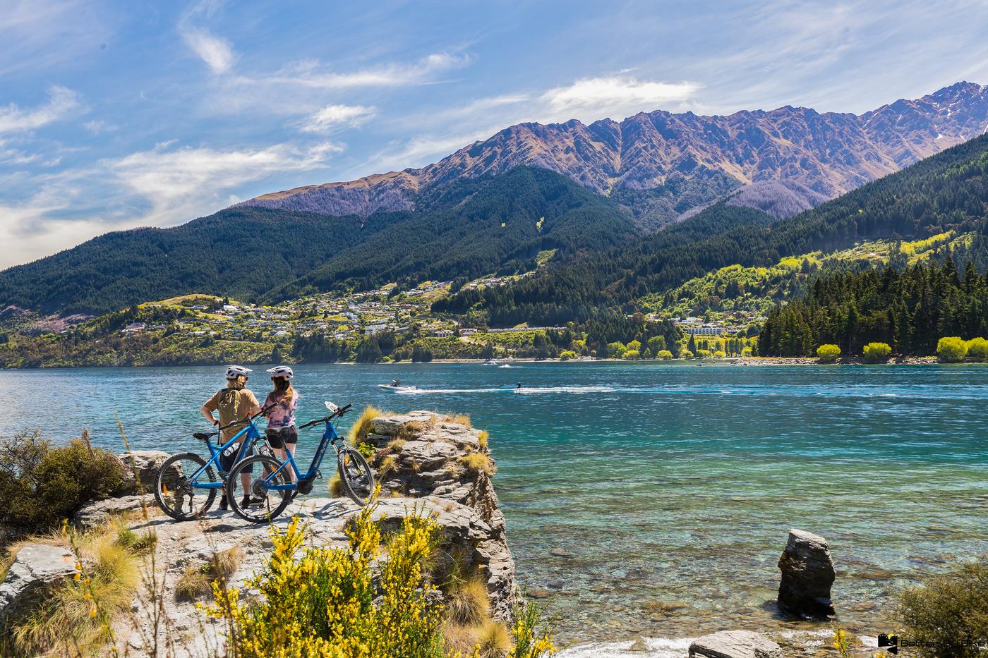 Two friends on the Kelvin Heights Sculpture trail admiring the view towards Queenstown with Ben Lomond in the background